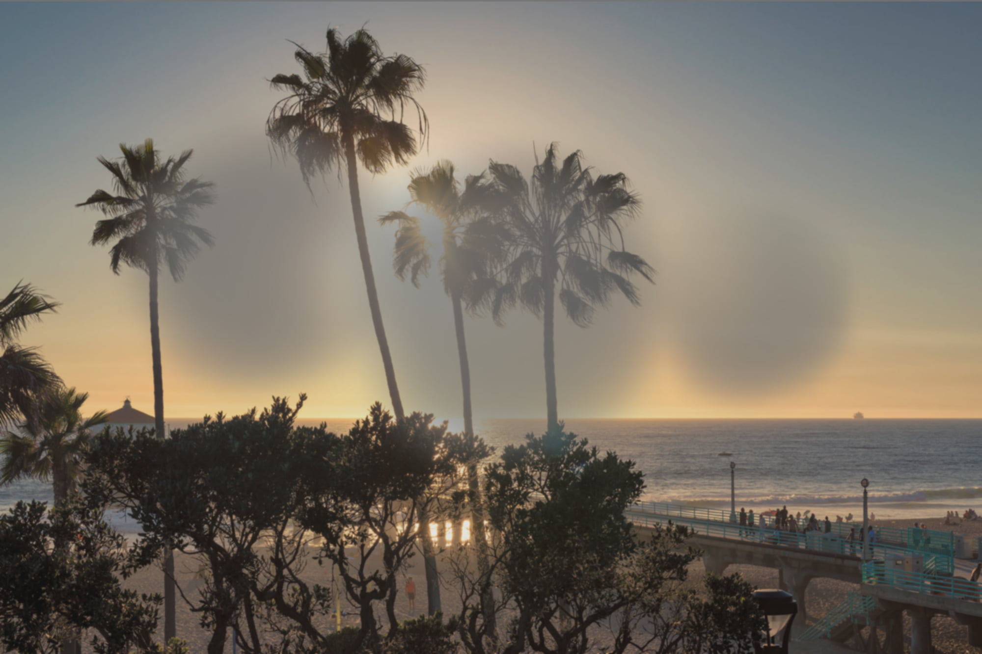 Macular Degeneration vision of a scenic view of a beach at sunset with palm trees silhouetted against the sky and a pier extending into the ocean - San Dimas Optometry Macular Degeneration vision of a scenic view of a beach at sunset with palm trees silhouetted against the sky and a pier extending into the ocean - San Dimas Optometry