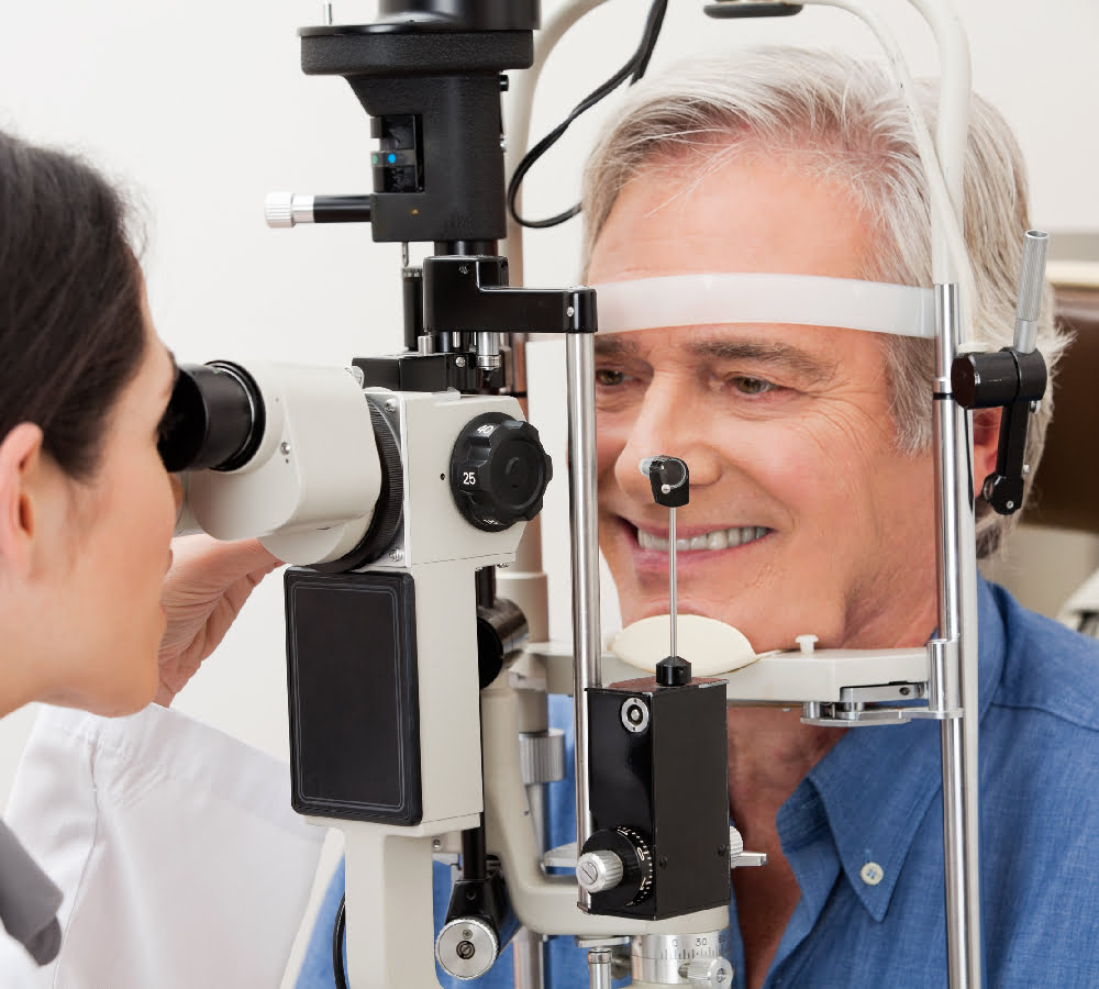 An older man receives an eye examination using a slit lamp at an optometrist's office - Myopia control